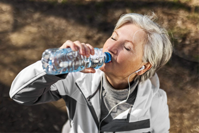Donna che beve una bottiglietta d'acqua